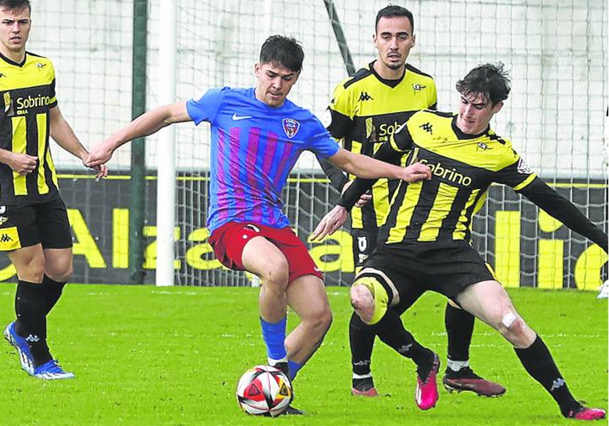 Javier Elías trata de robar un balón a un jugador de Leioa.