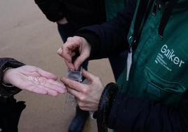 Operarios recogen pellets este miércoles en la playa de la Arena.