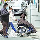 Una cuidadora pasea a una persona dependiente.