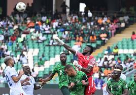 Owono despeja de puños un balón entre un mar de jugadores de la selección de Nigeria