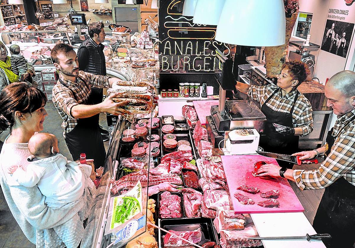 Clientes atendidos en una carnicería de Bilbao.