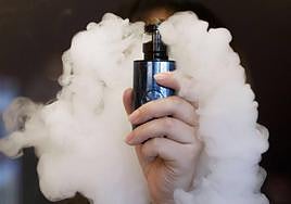 Una vendedora sujeta un cigarrillo electrónico.