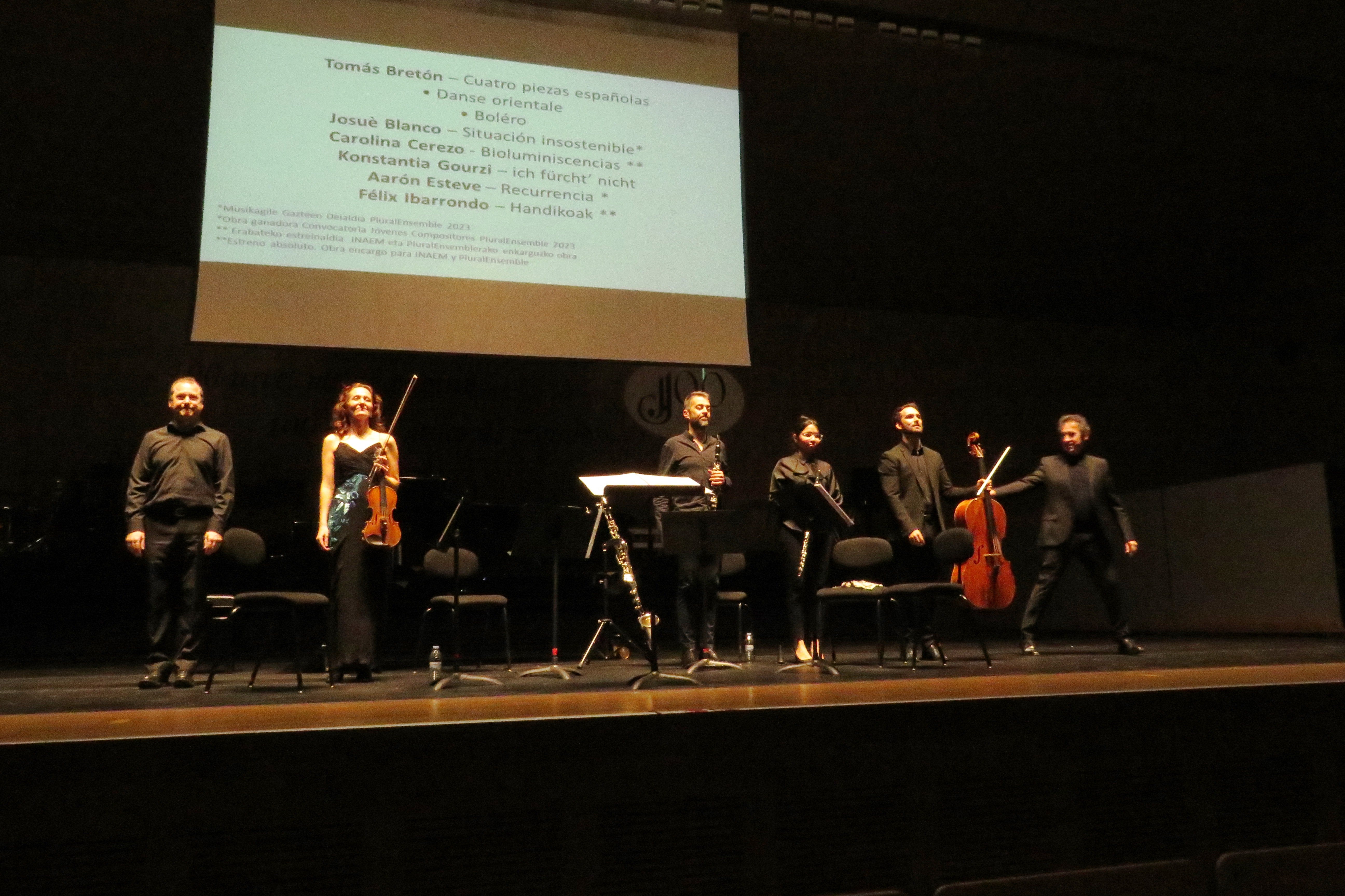 Los seis actantes saludando al final, bajo la pantalla con el repertorio