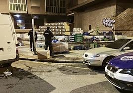 Dos ertzainas custodian la mercancía incautada.