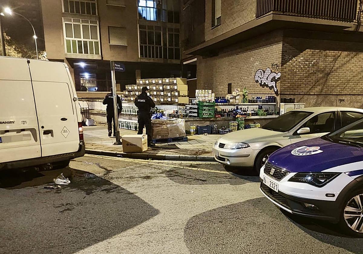 Dos ertzainas custodian la mercancía incautada.