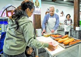 Una mujer con su niña recoge un menú en el comedor de Berakah, obra social ligada a la Diócesis.