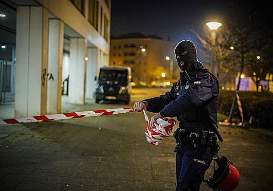 Un ertzaina retira la cinta de seguridad tras finalizar el operativo en la calle Helsinki.