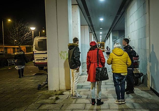 Varias personas conversan con un agente de la Ertzaintza.