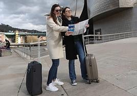 Dos turistas consultan un plano junto al Guggenheim.