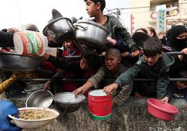 Niños palestinos esperan comida en Rafah.