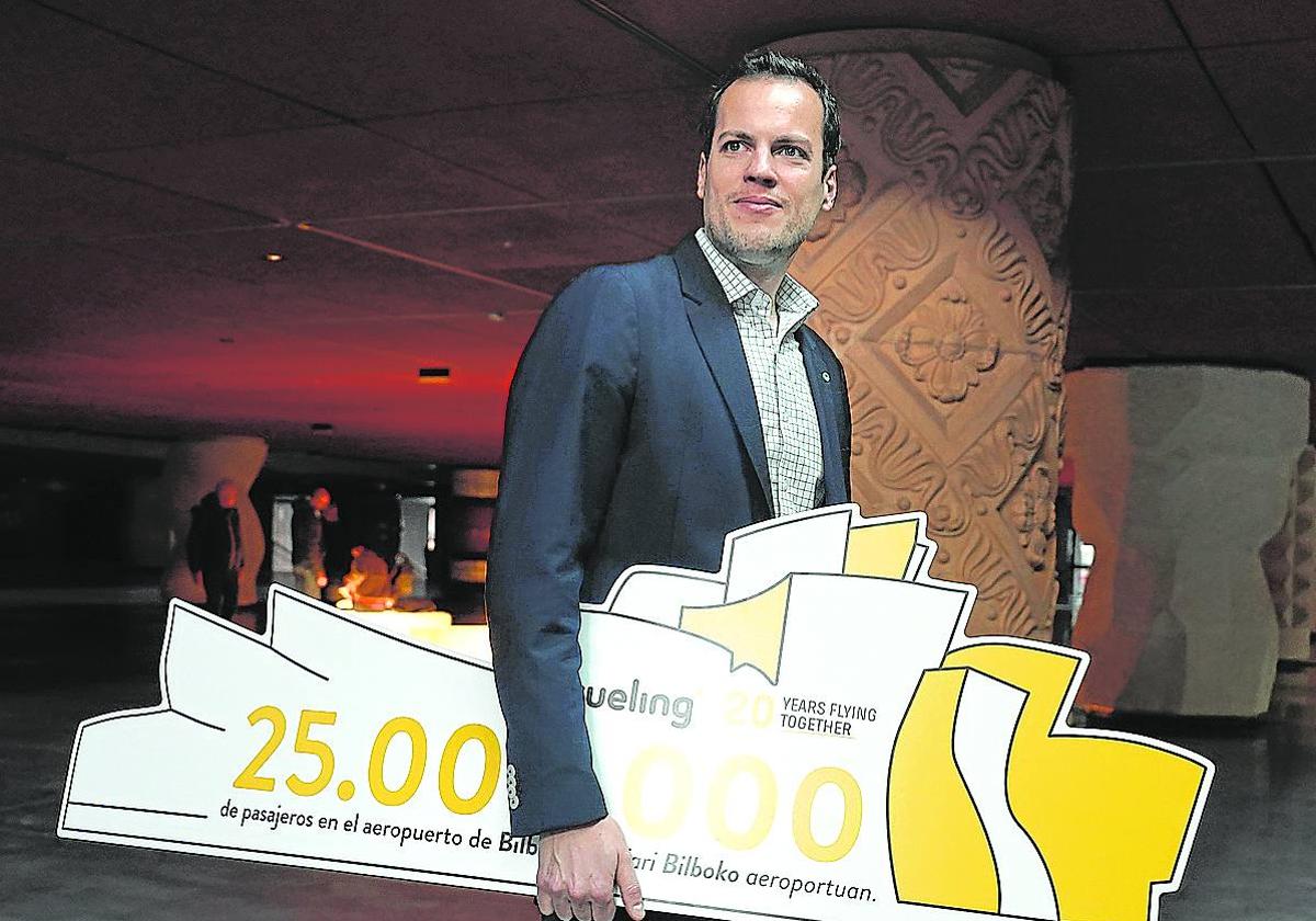 Jordi Pla con el cartel que celebra los 25 millones de viajeros con Vueling ayer en el Azkuna Zentroa.