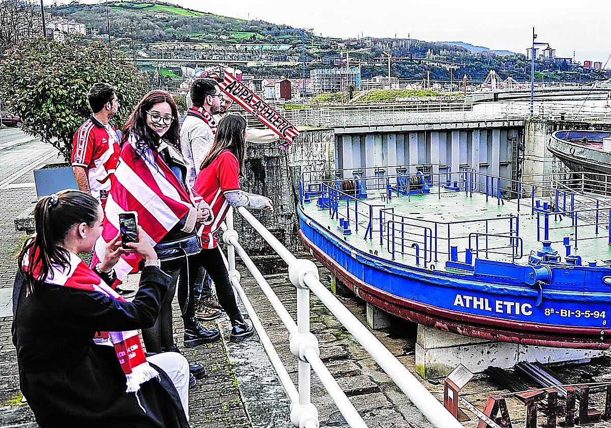 Un grupo de jóvenes aficionados del Athletic posa ayer junto a la gabarra.