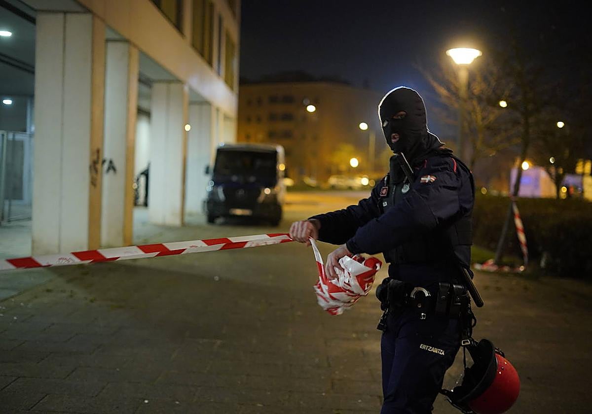 Un ertzaina recoge la cinta de seguridad tras el despliegue en el bloque del exetarra el pasado 4 de febrero.
