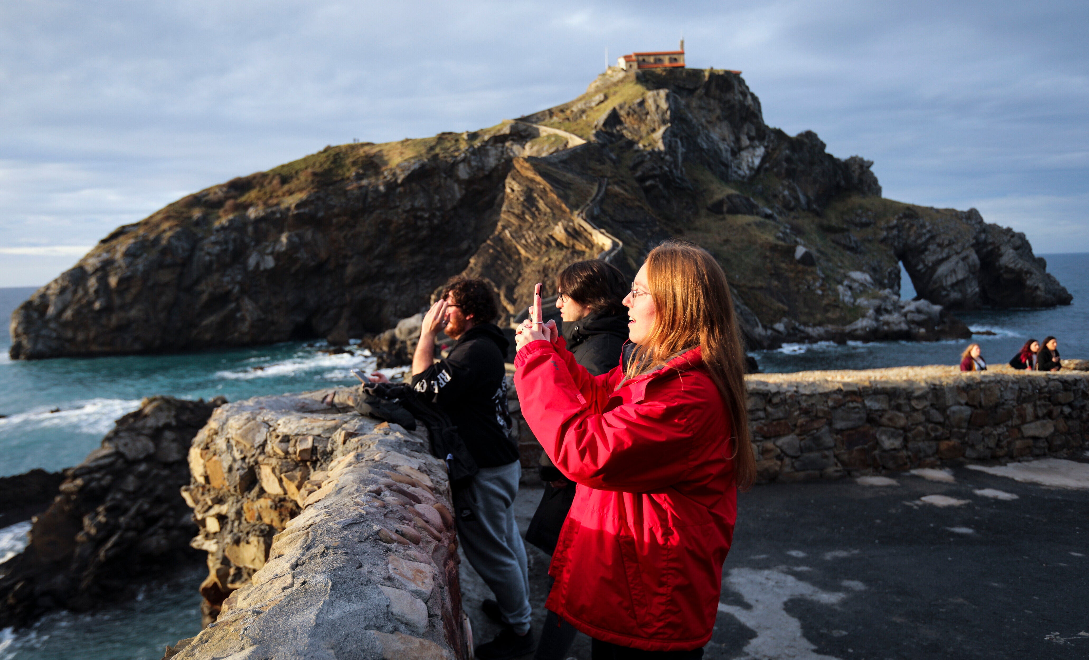 Varias turistas sacan fotos del entorno de San Juan de Gaztelugatxe, en Bermeo.