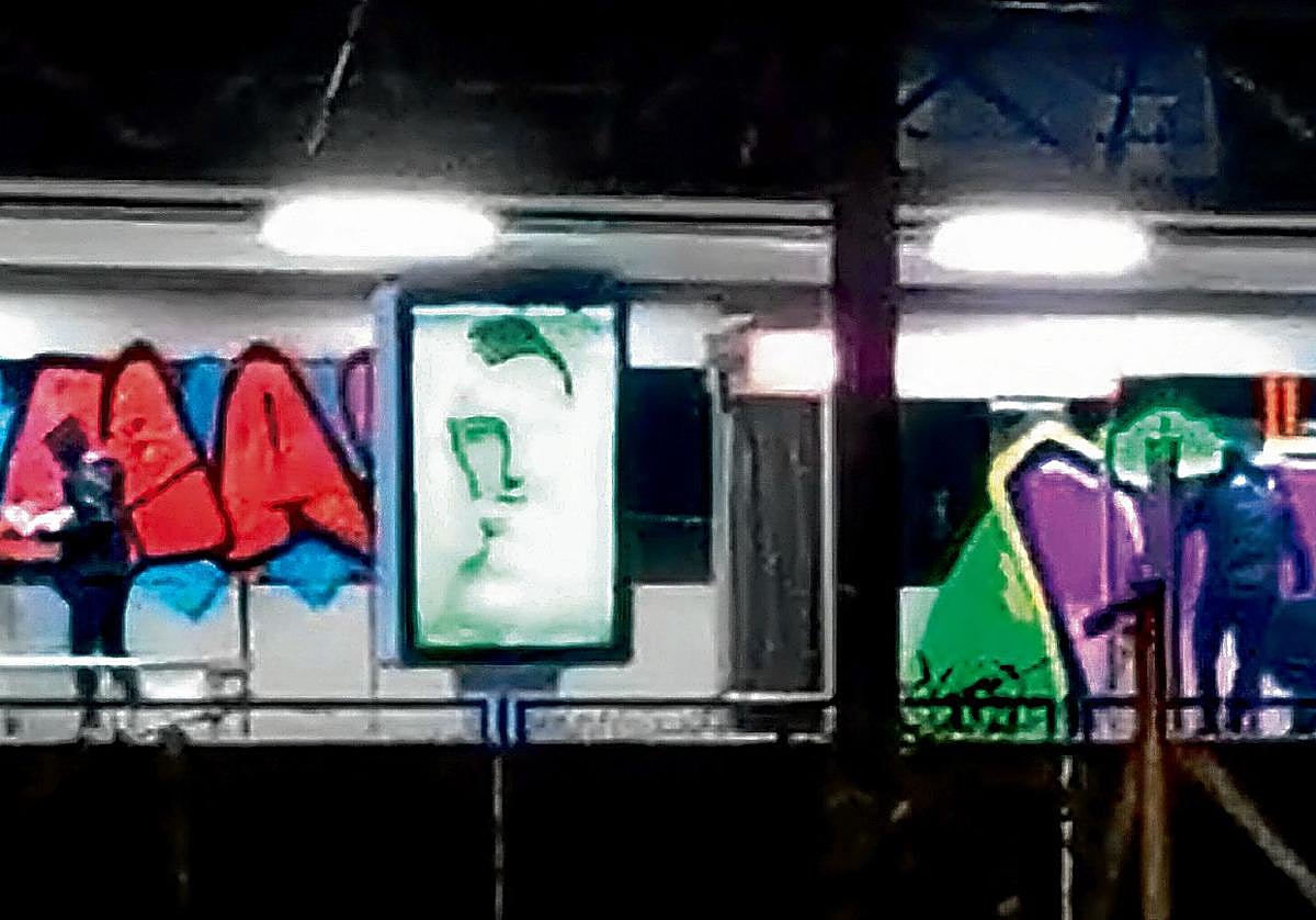 Un grupo de grafiteros pinta un vagón de metro en la estación de Ibarbengoa en Getxo.
