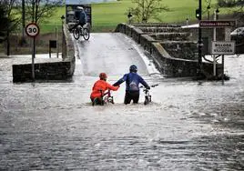 Ciclistas en la zona de Víllodas en unas inundaciones del año 2016.