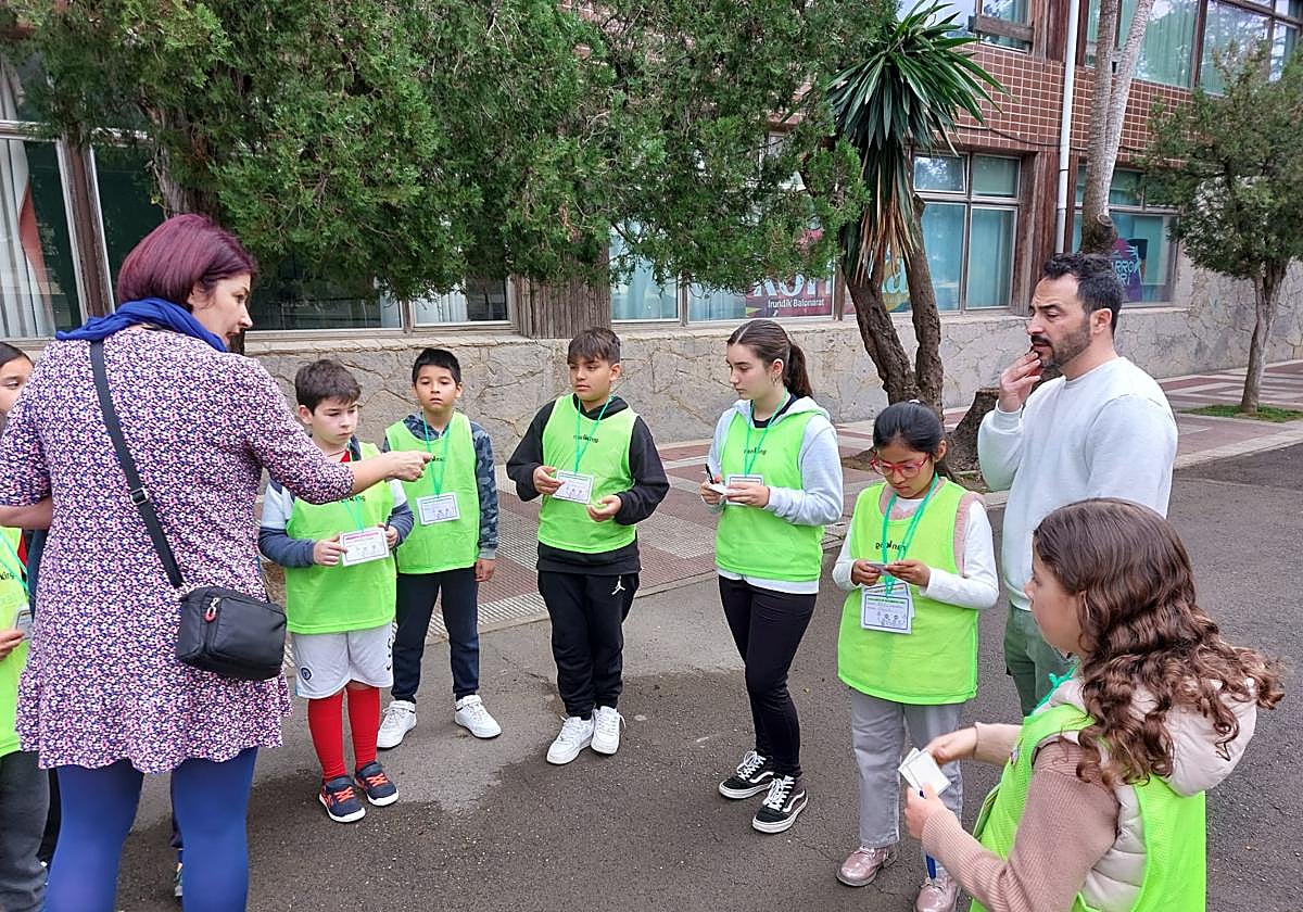 Una profesora del colegio público de Romo entrega los talones de multas cívicas a los alumnos.