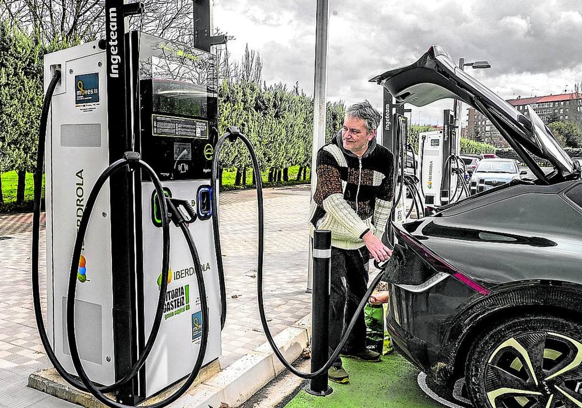 Un conductor recarga su coche eléctrico en un punto público situado en una calle de Vitoria.