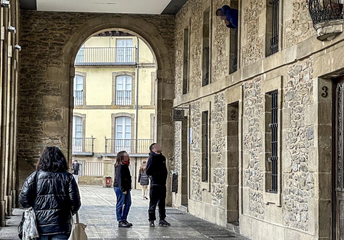 Uno de los asaltantes se asoma al inmueble okupado, en el número 2 de Los Arquillos.