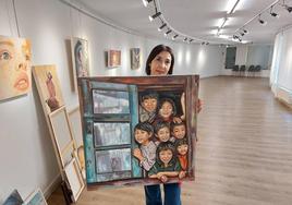 La artista posa con un cuadro con miradas de jóvenes en la sala de exposiciones de Ezkurdi.