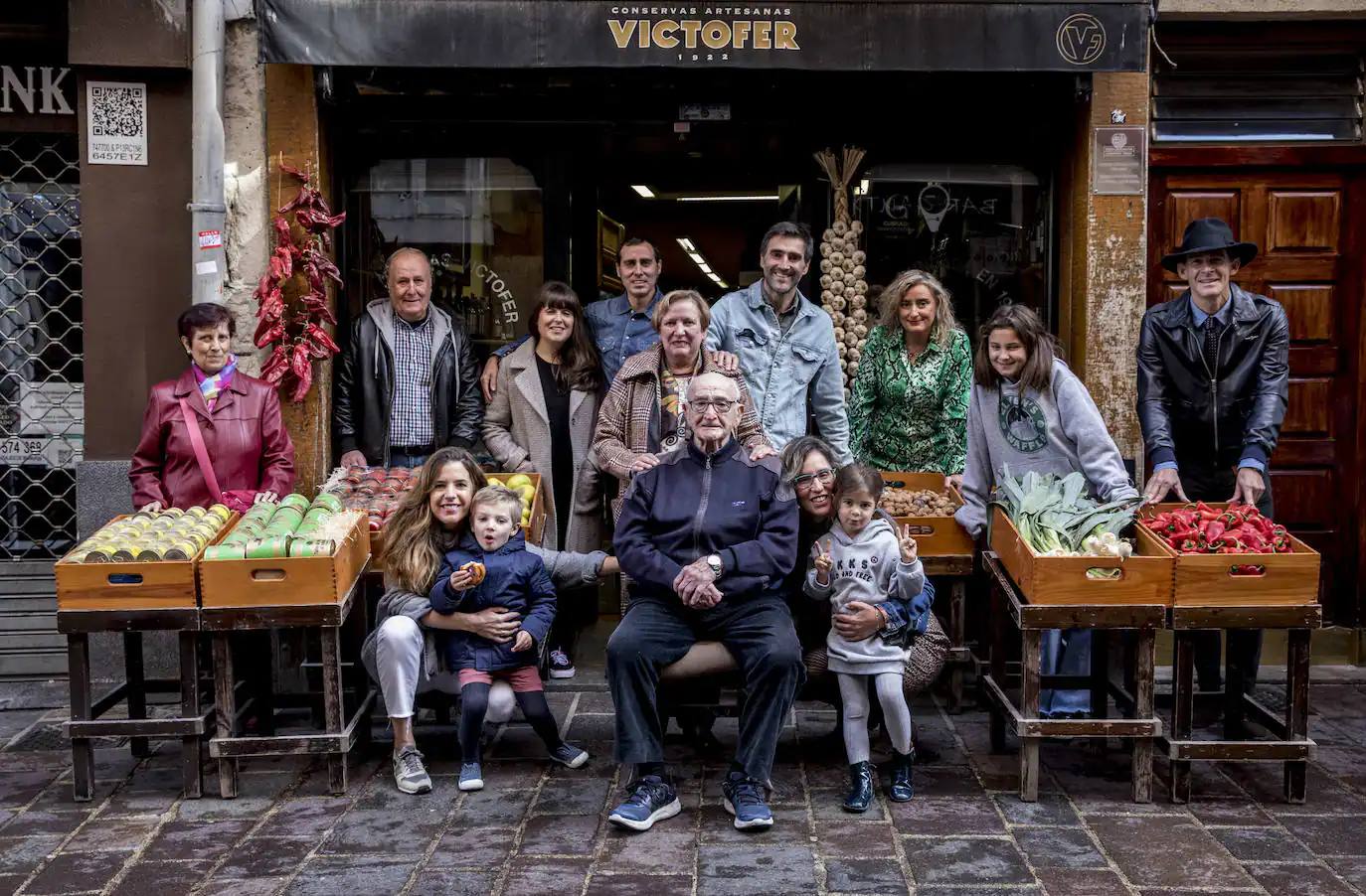 Víctor Fernández, rodeado de su familia, en un retrato a la puerta de su histórico ultramarinos de la Cuchillería tomado en 2021.