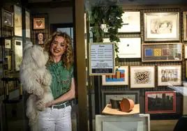 Judith García posa con su perro Tyrrel en su tienda de marcos, escondida en unas galerías de Bilbao.