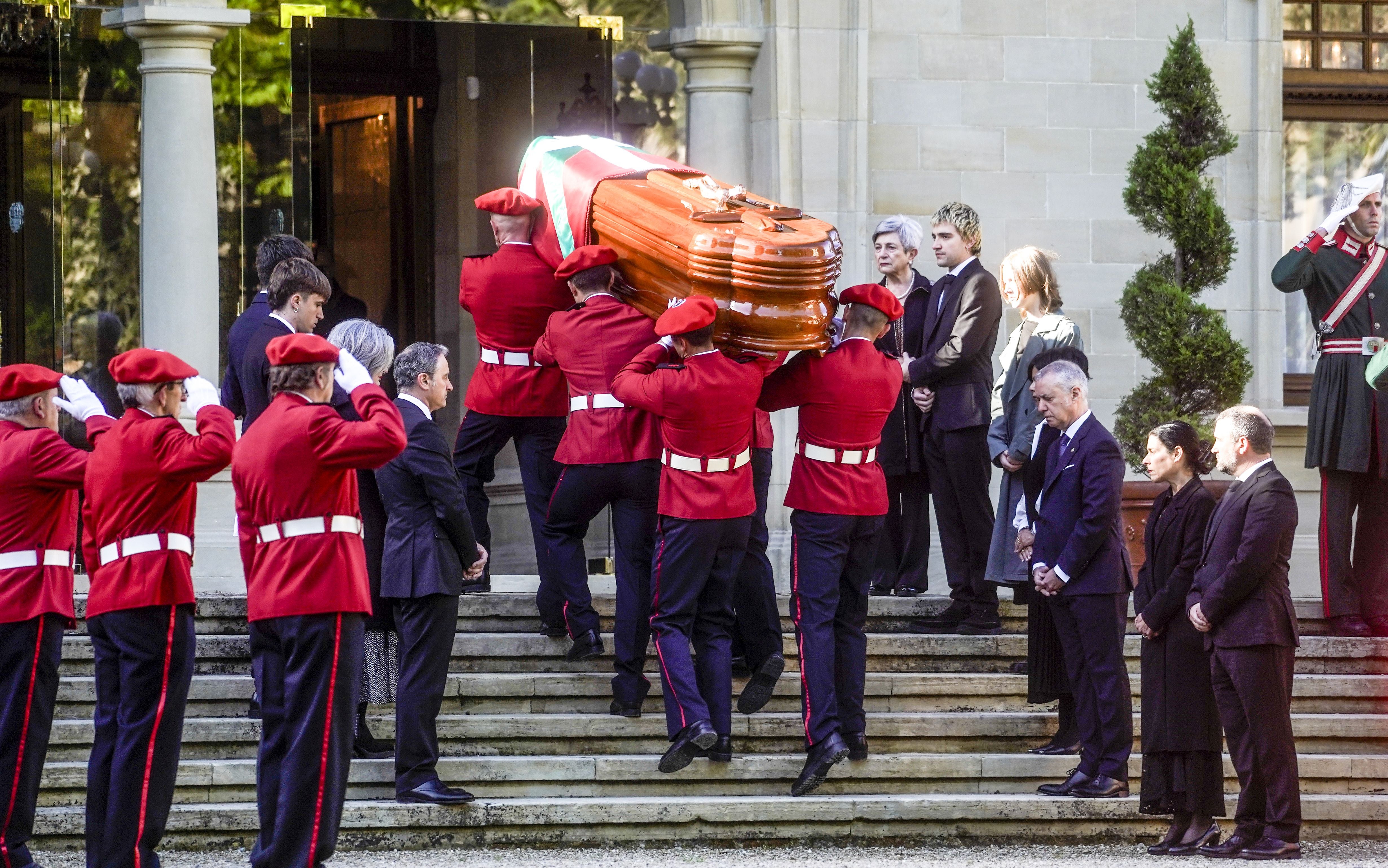 El féretro con los restos mortales de Ardanza, lehendakari entre 1985 y 1999, a punto de acceder al interior de Ajuria Enea. La capilla ardiente se ha instalado en el interior del palacio vitoriano. Iñigo Urkullu y la familia del expresidente del Gobierno vasco con su esposa Gloria Urtiaga, sus hijos Nagore y Aitor, junto a sus parejas y sus nietos presencian el momento.