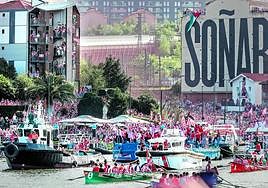 La gabarra remonta la ría con el estadio de San Mamés al fondo, como orgulloso testigo de la celebración.