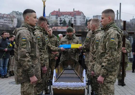 Soldados ucranianos realizan un homenaje al cadáver de un compañero entregado por Rusia.