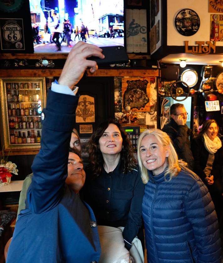 Imagen secundaria 2 - En la foto superior, Ayuso junto a los clientes del local. Abajo, a la izquierda, en la Plaza del Carmen junto a Carlos García, Raquel González y Miguel Ángel Rodríguez. A la derecha, un selfi con García y Esther Martínez.