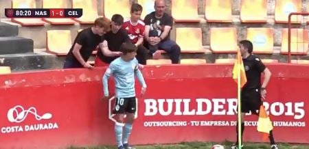 Dos aficionados pellizcan a un jugador del Celta en un córner