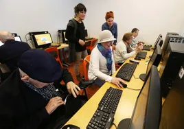 Un grupo de personas mayores recibe un curso para desarrollar habilidades informáticas.