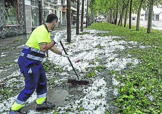 Un trabajador retira granizo y hojas de la plaza de los Fueros.
