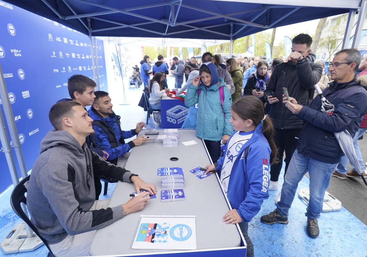 Los jugadores y jugadoras del Alavés firman autógrafos y se sacan fotos.