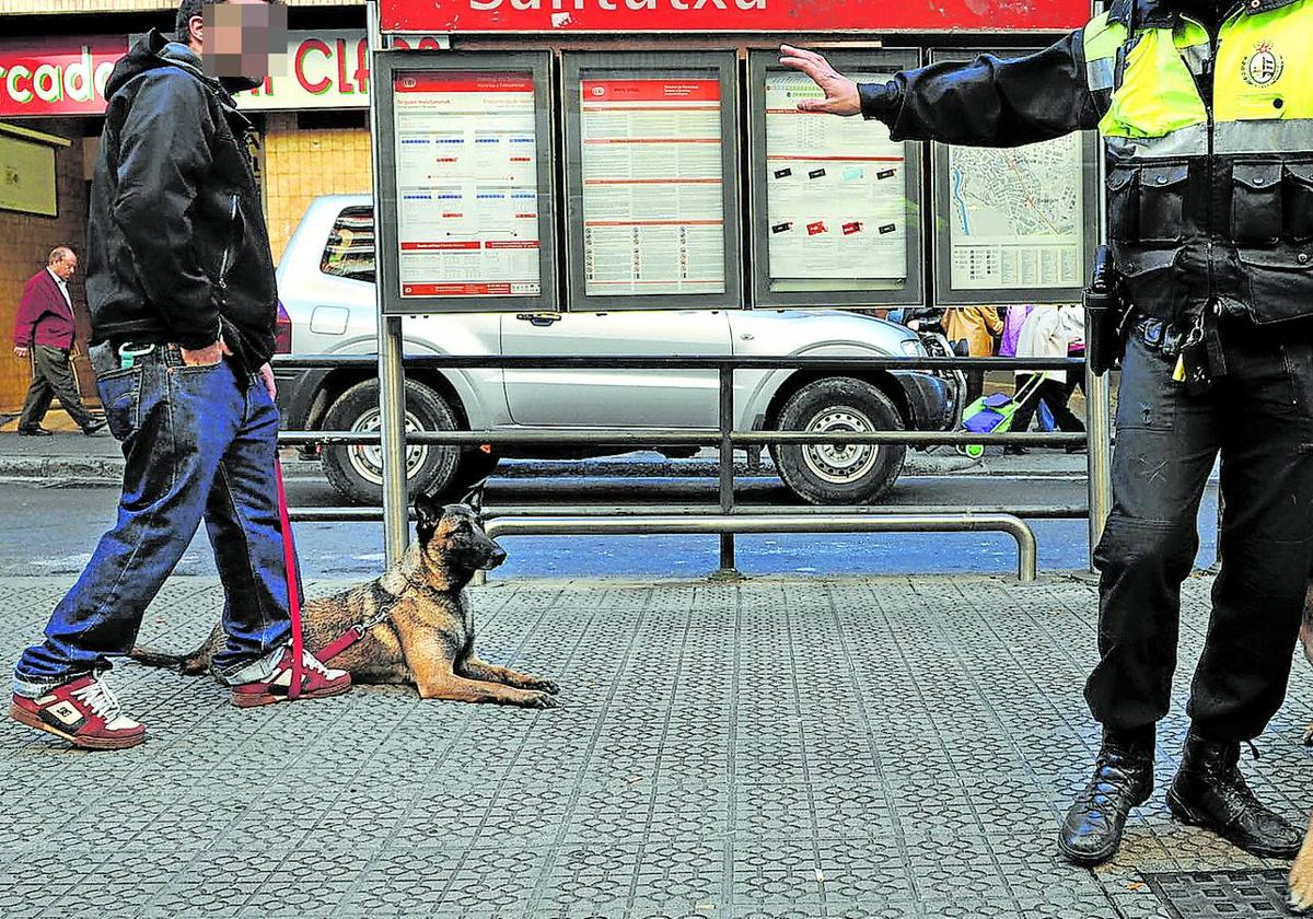 Un policía municipal, de patrulla con un perro adiestrado.