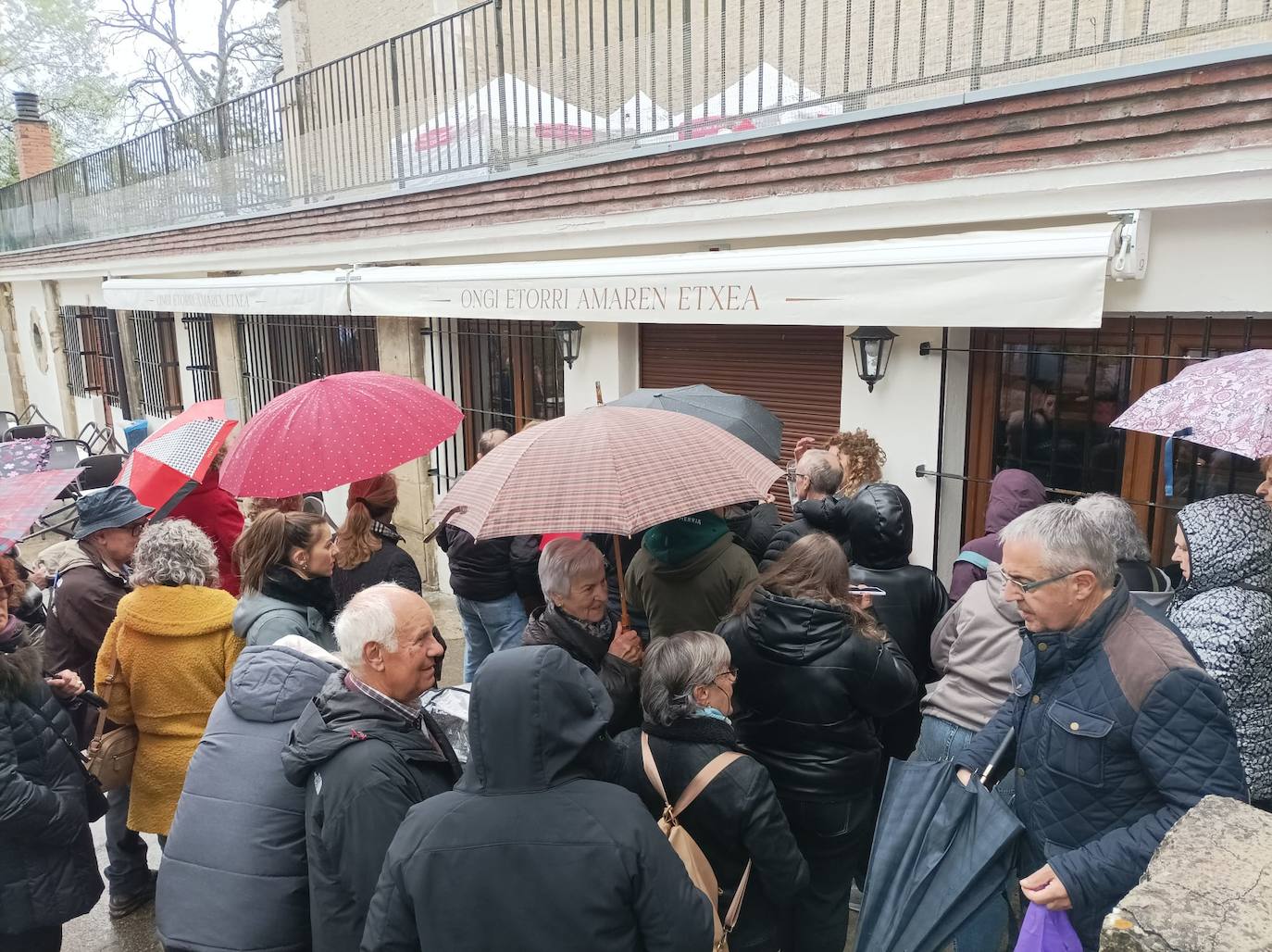 Un grupo de personas esperan a que las monjas Peregrinas regresen de misa y abran el bar.