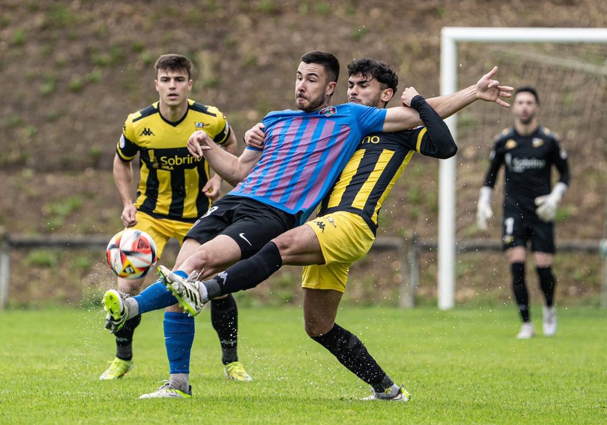 Aritz Pascual y Oier del Cura pugnan por un balón en Sarriena.