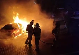 Imagen de los bomberos extinguiendo las llamas de los vehículos afectados durante la pasada madrugada.