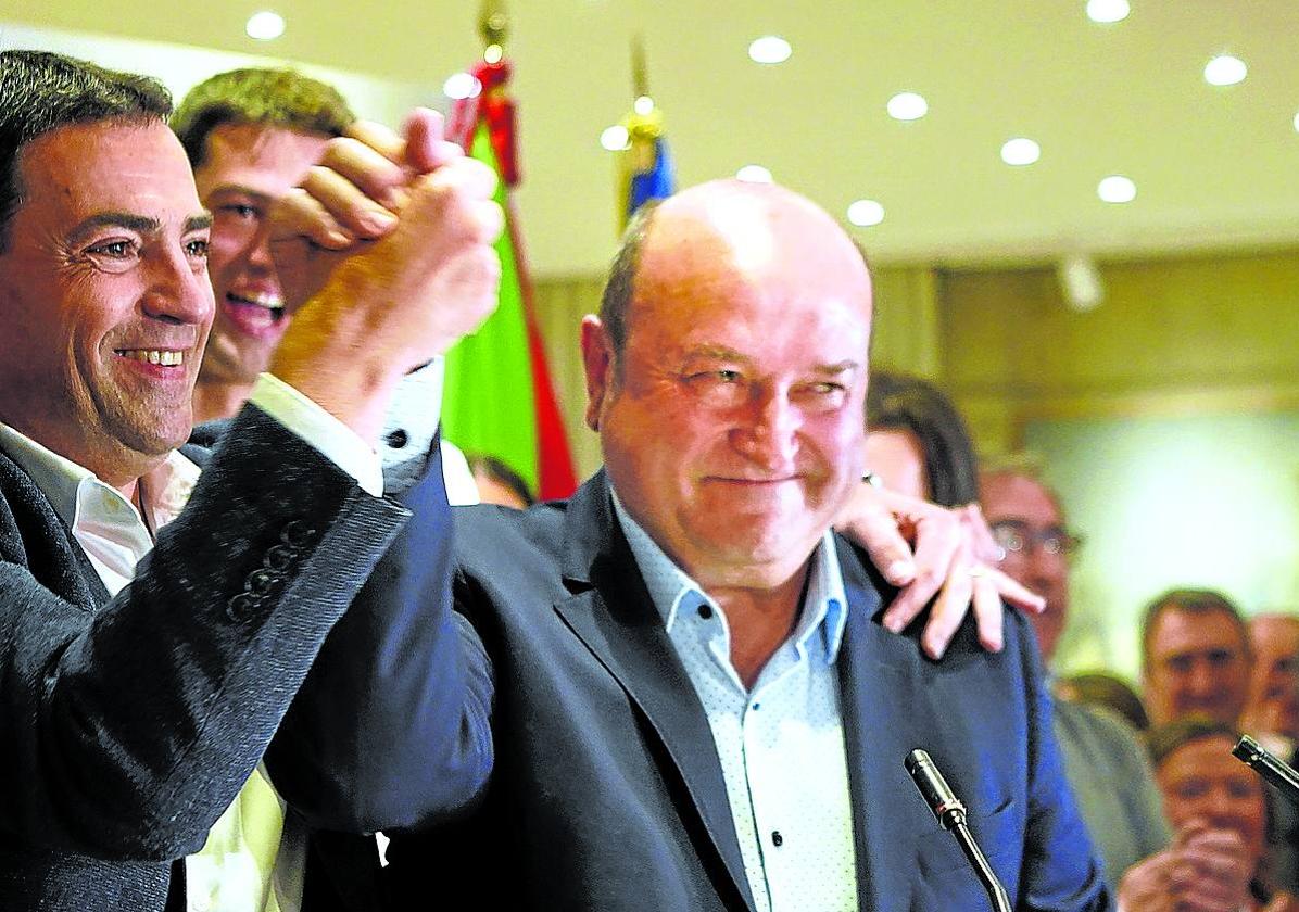 Imanol Pradales levanta el brazo de Andoni Ortuzar durante la noche electoral en Sabin Etxea. Ignacio Pérez