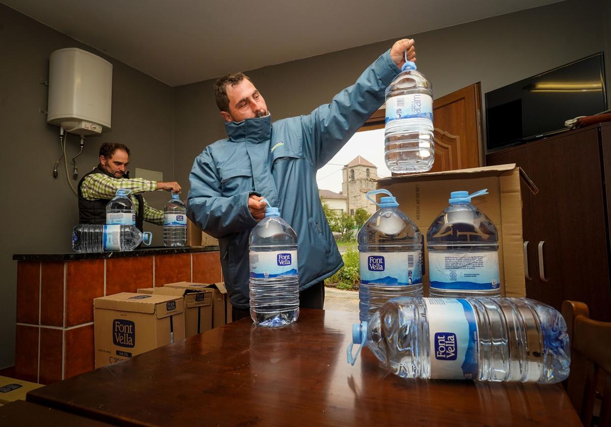 Roberto y Rubén Aguirre, vecinos del concejo de Mandojana, con las garrafas de agua embotellada.