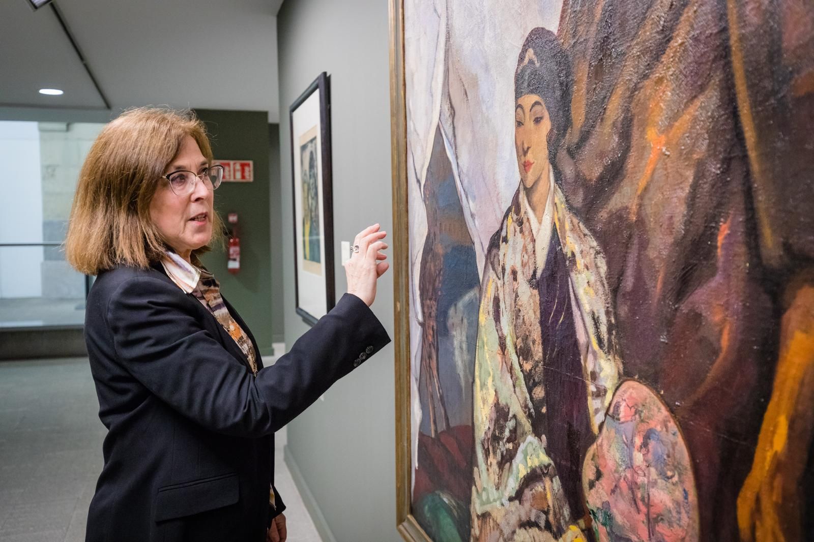 Sara González de Aspuru, directora del Bellas Artes de Álava, junto a la obra 'Mongoles', de Gustavo de Maeztu.