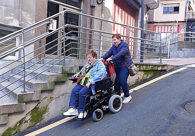 Al carecer de acera, Marisa debe bajar la vía por la carretera y agarrada por su hermana para no caer calle abajo debido a la gran inclinación.