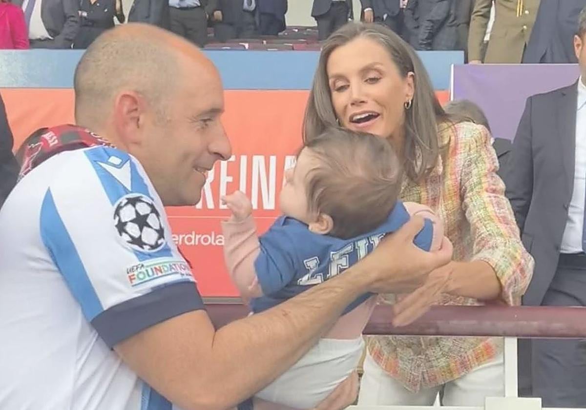 La reina Letizia cogiendo a la pequeña aficionada en brazos.