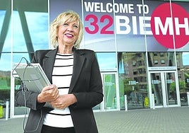 La directora de la Bienal, Mari Carmen Gorostiza, frente a los carteles del evento que ya se han montado en el BEC.
