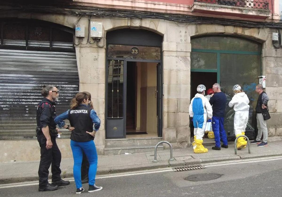 Agentes de la Policía Científica, con buzos, acceden al interior de la lonja incendiada en Atxuri.