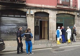 Agentes de la Policía Científica, con buzos, acceden al interior de la lonja incendiada en Atxur