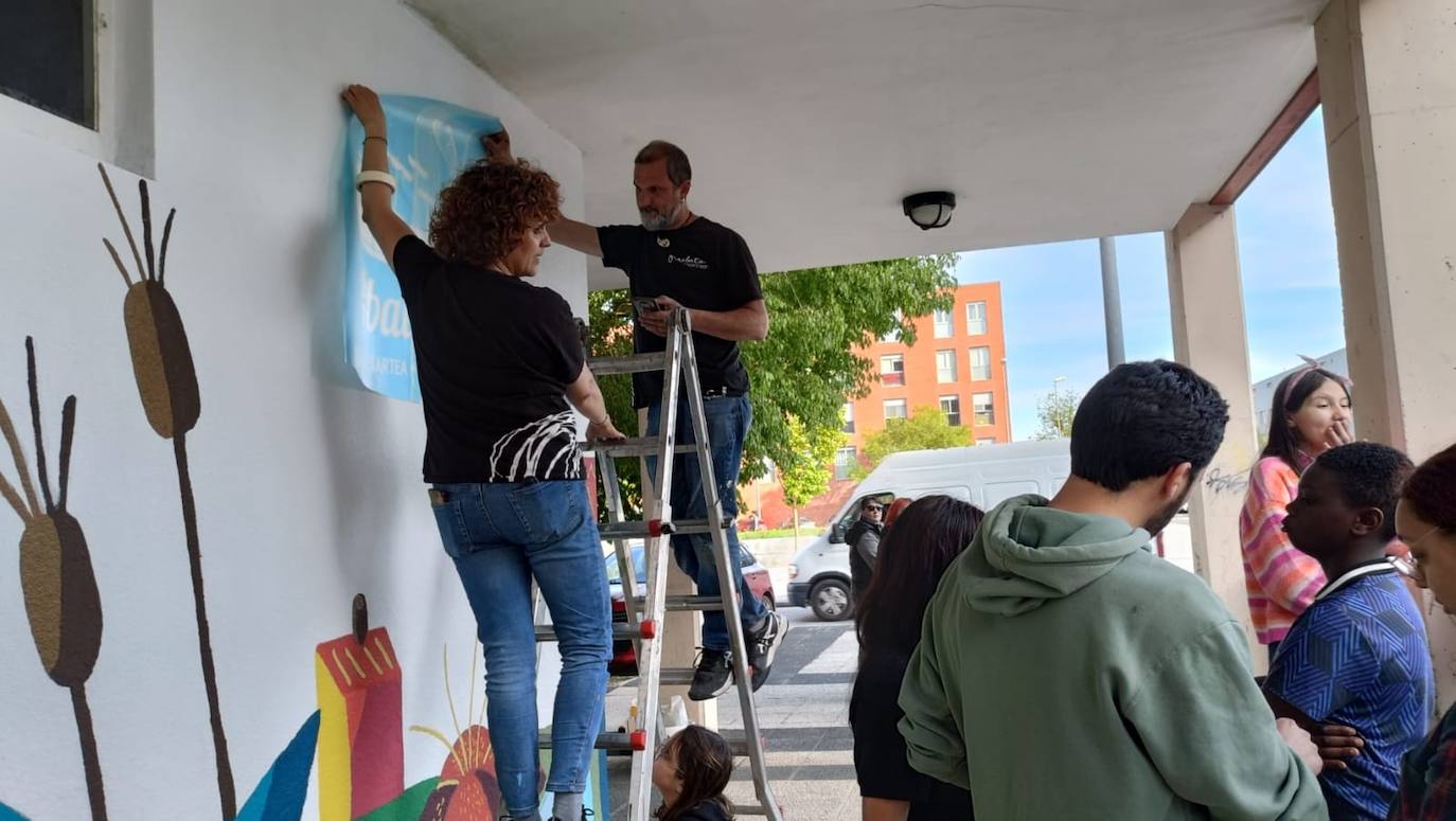 En imágenes: 150 vecinos de Ibaiondo pintan un mural de 24 metros