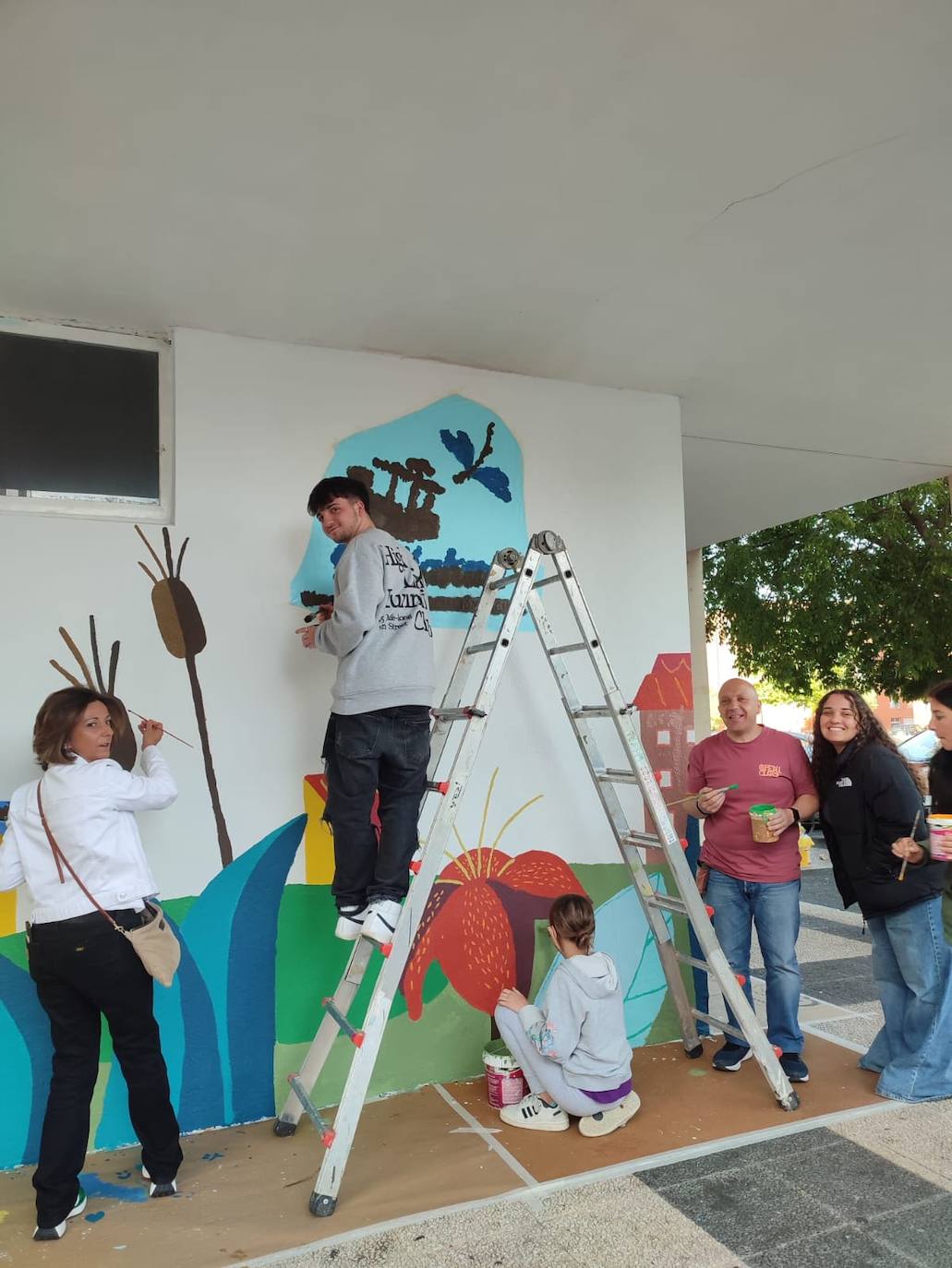 En imágenes: 150 vecinos de Ibaiondo pintan un mural de 24 metros