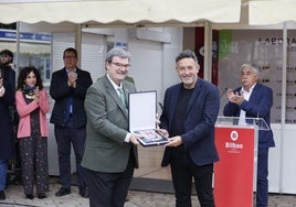 El escritor Mikel Santiago recibe el premio Atea de manos de Juan Mari Aburto.