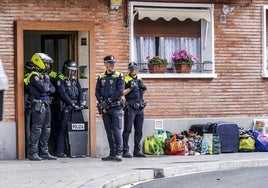 Agentes de la Policía Local de Vitoria aguardan en el portal de una vivienda que acaba ser objeto de un desahucio.